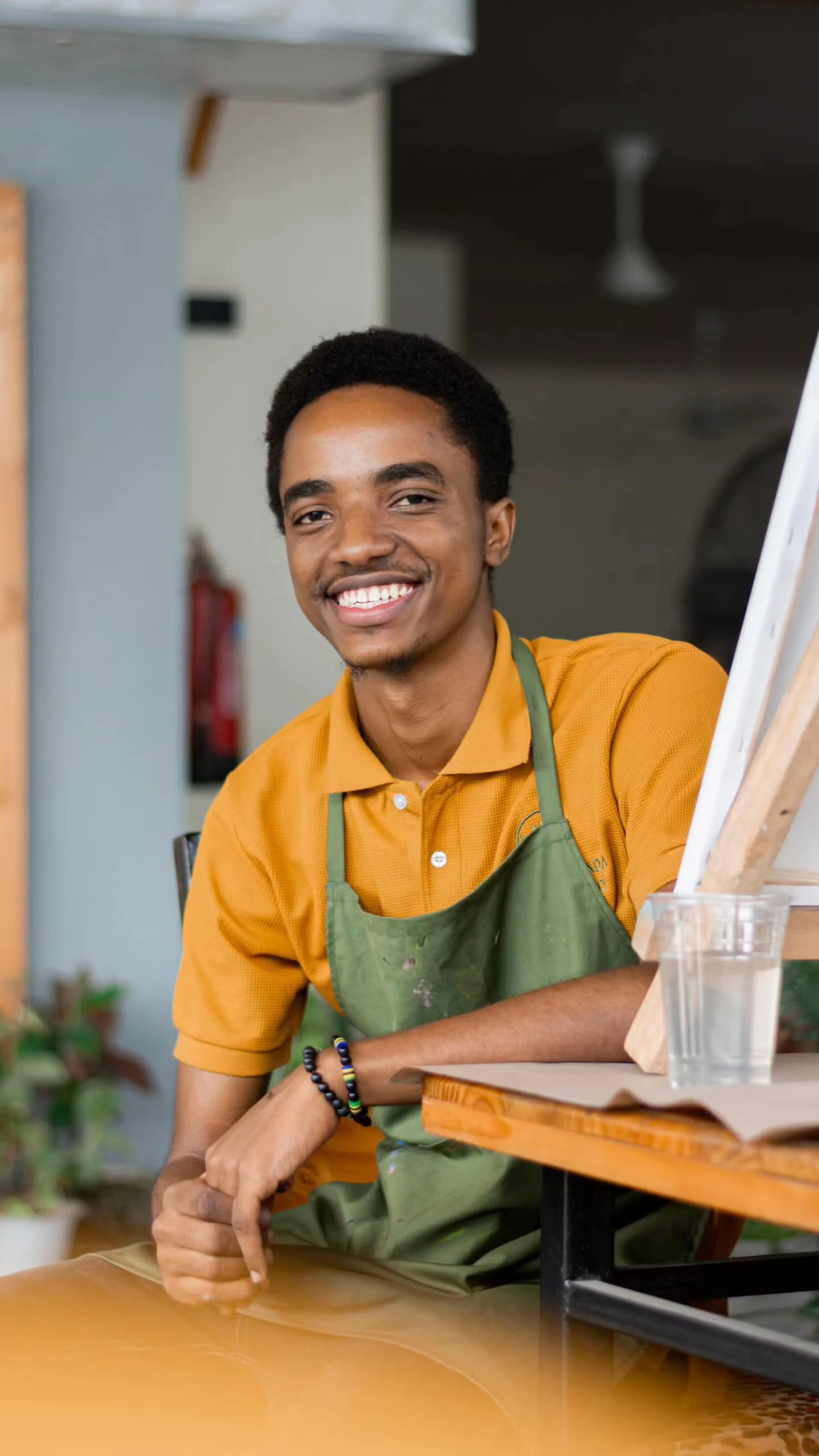 Close-up of Henry Kirenga creating textured artwork